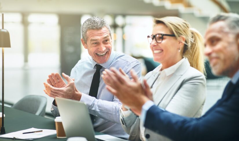 Mature businesspeople smiling and clapping during an office presentation Mature businesspeople smiling and clapping during an office presentation